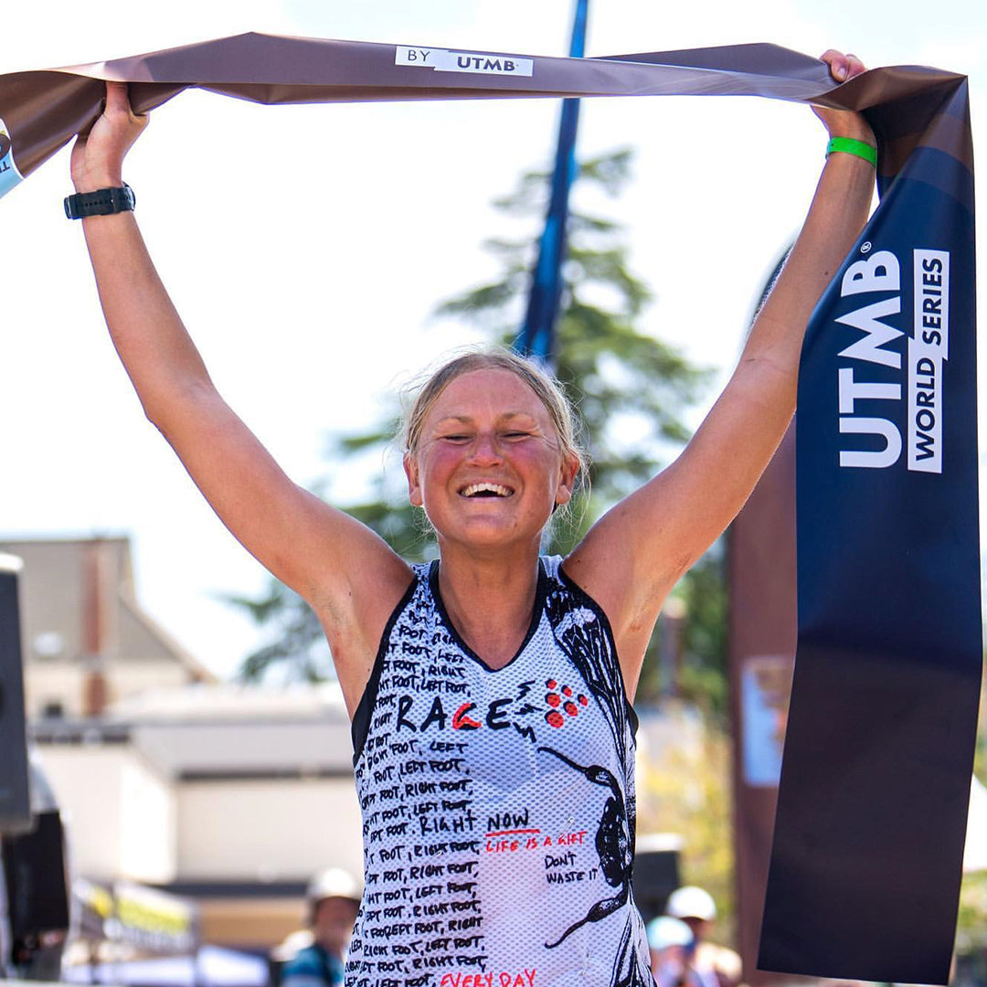 Female runner celebrating at the finish line of a race