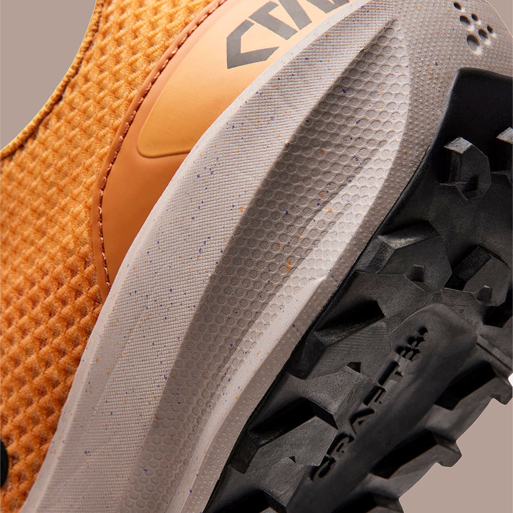 Gros plan sur la semelle d'une chaussure de randonnée avec motif de bande de roulement et logo de la marque.