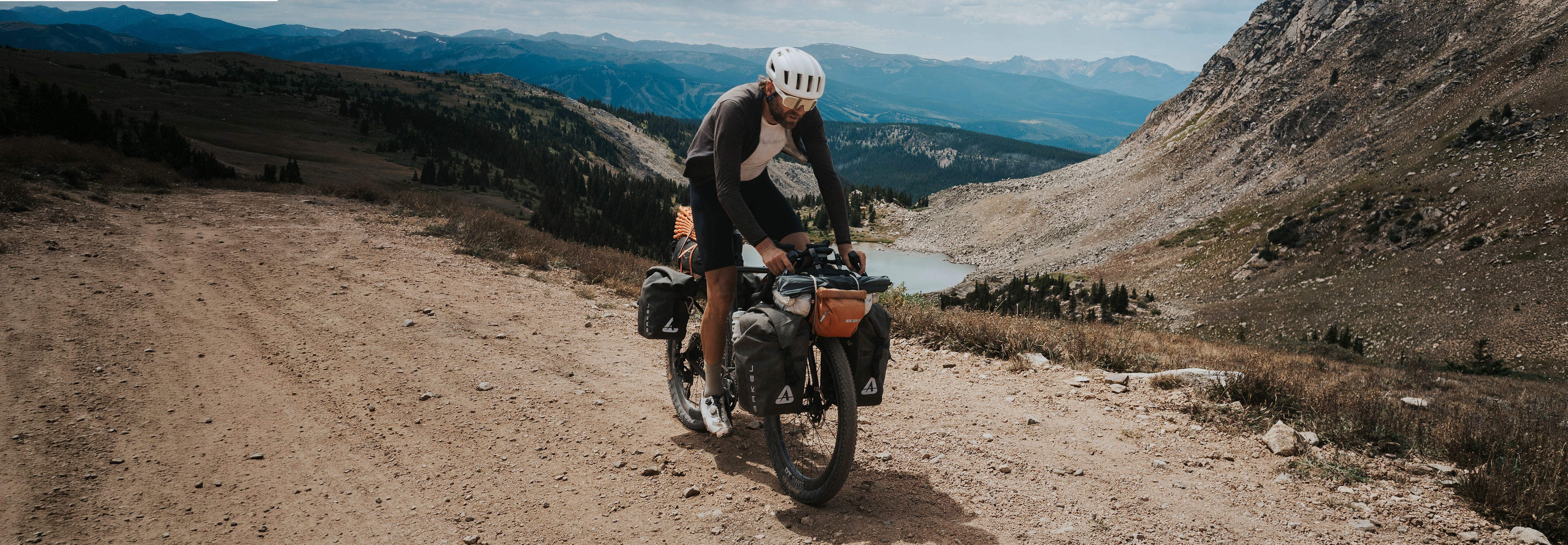 Person riding a motorcycle on a mountain road with scenic views.