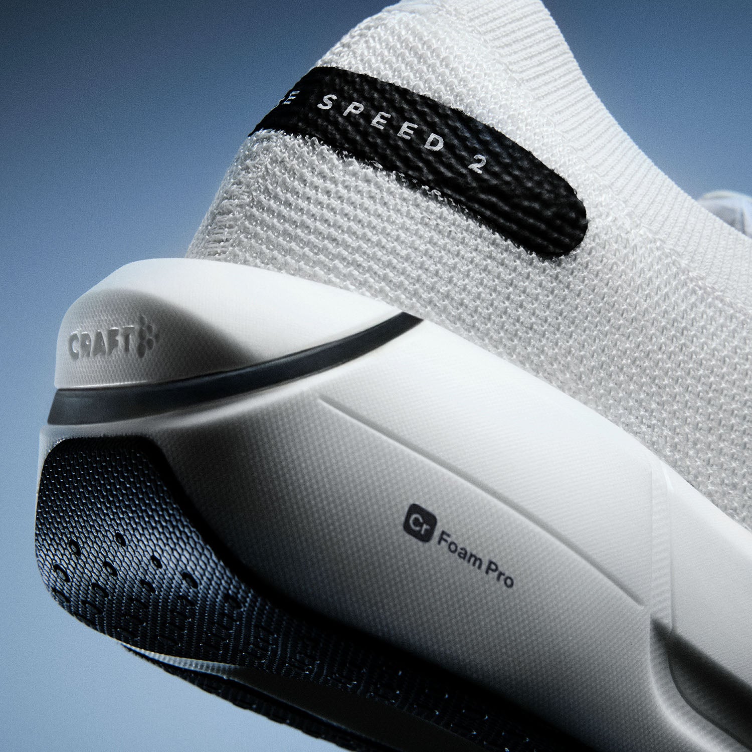 Gros plan d'une chaussure de sport blanche avec des accents noirs sur fond bleu