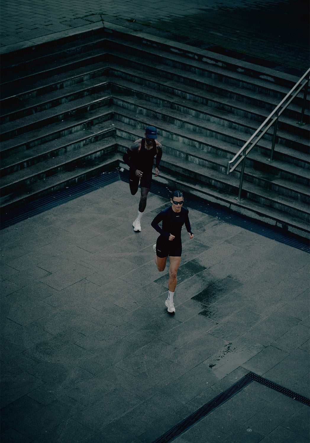 Deux personnes courant sur une piste circulaire avec des marches en arrière-plan