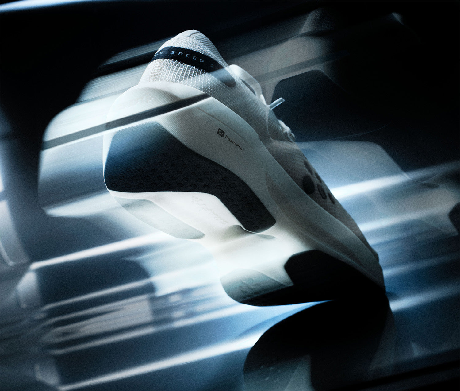 Baskets blanches à semelle noire sur une surface réfléchissante