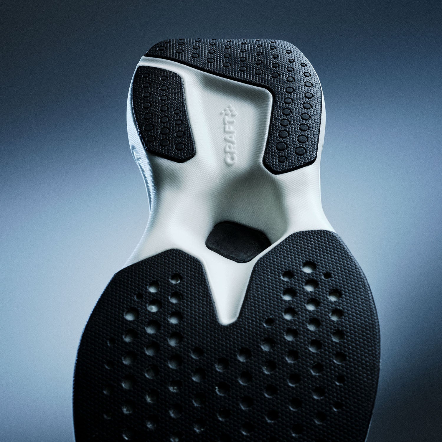 Gros plan d'une semelle de chaussure avec motif de bande de roulement sur fond bleu dégradé