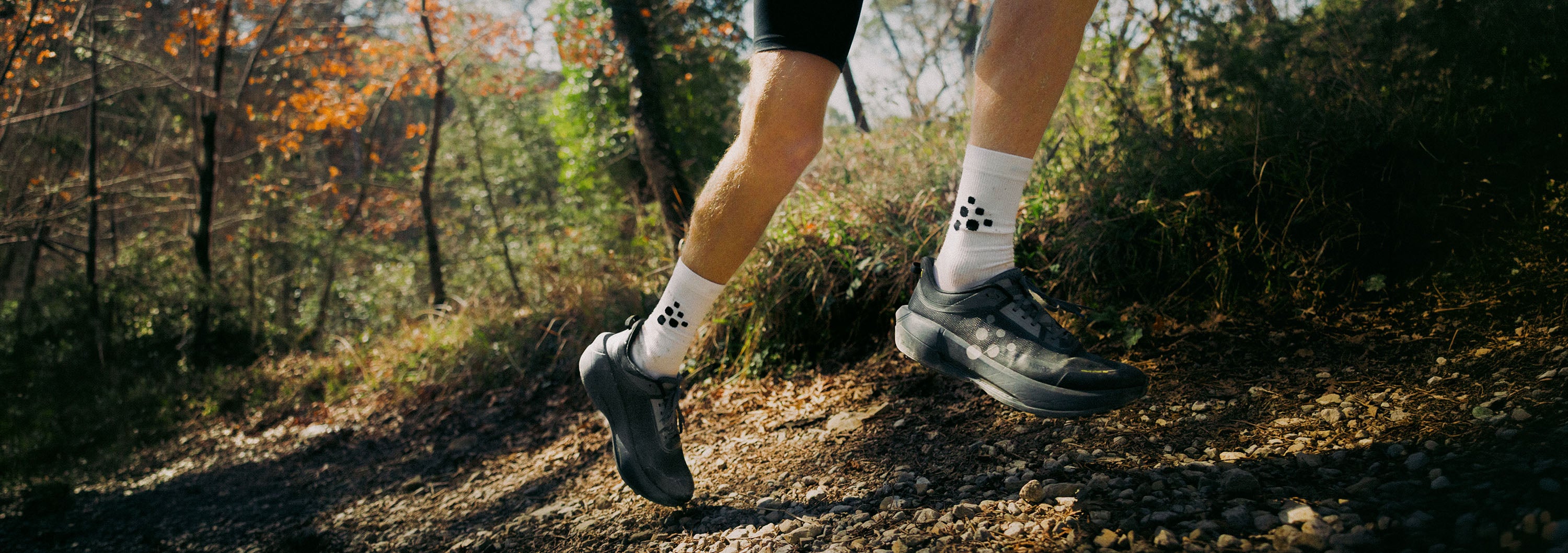 Person running on a trail with autumn foliage