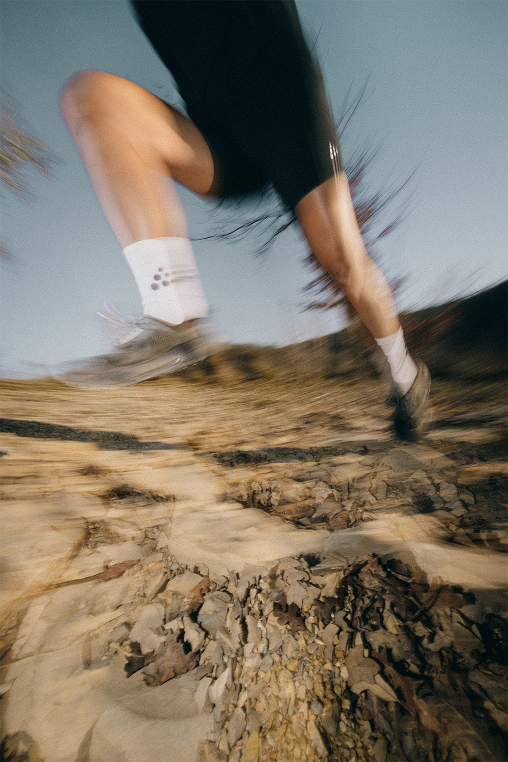 Person running on a rocky trail with a blurred background