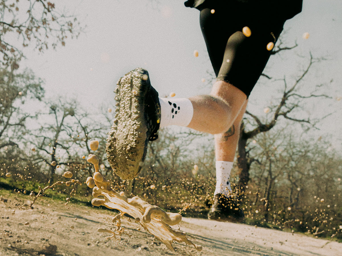 Person running on a dirt path with a log in the foreground