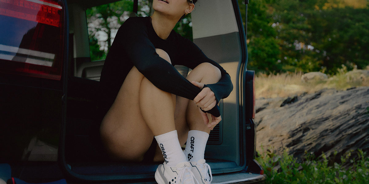 Person sitting in the open door of a vehicle with nature in the background