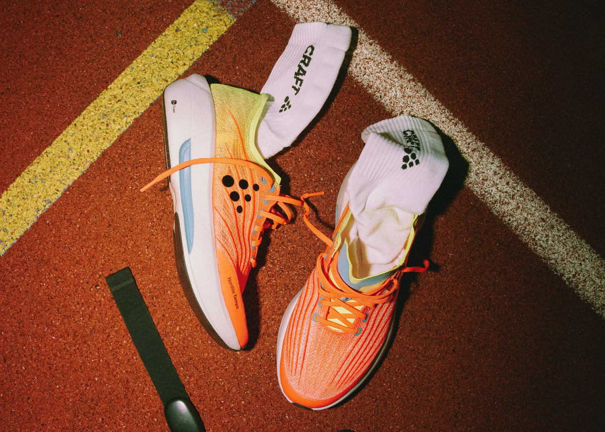 Shoes and socks flat lay on running track.