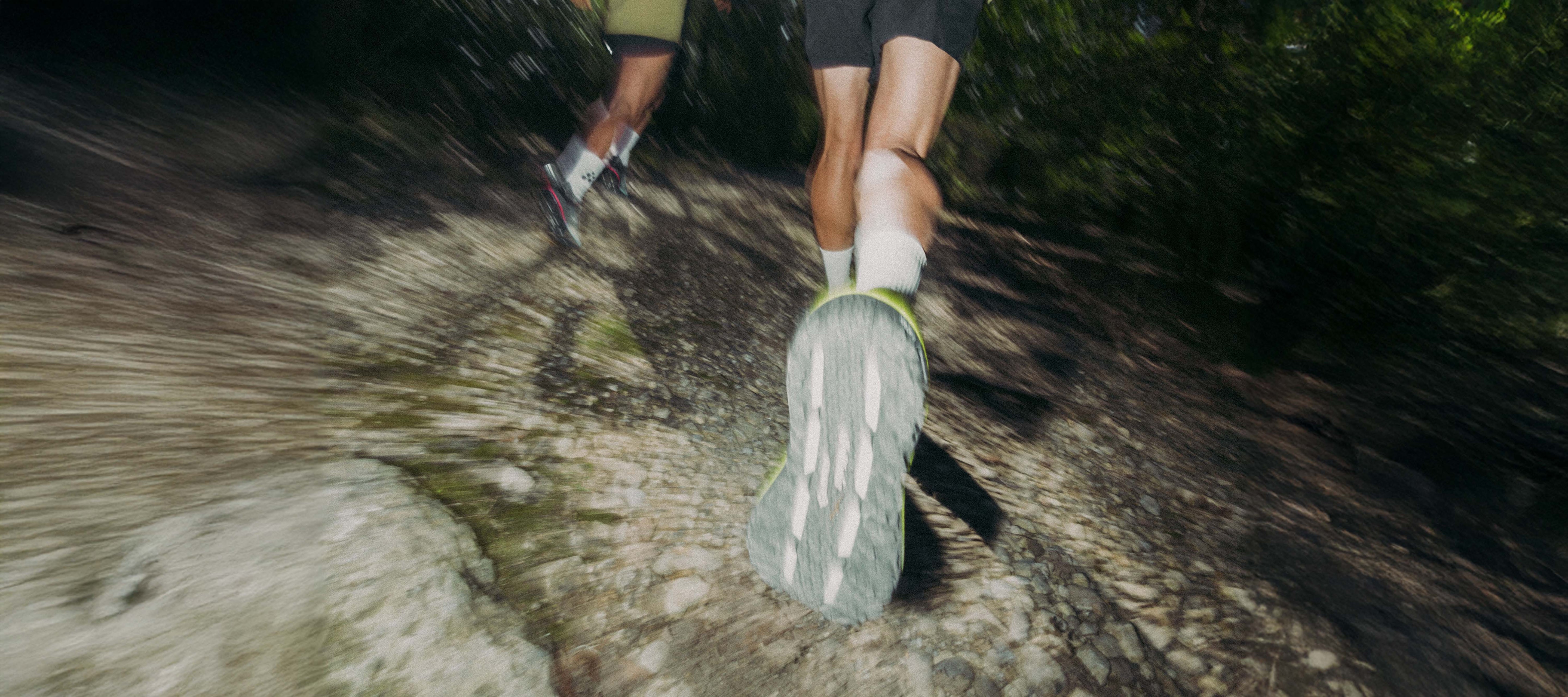 Close-up of a person running on a trail with focus on the shoes.