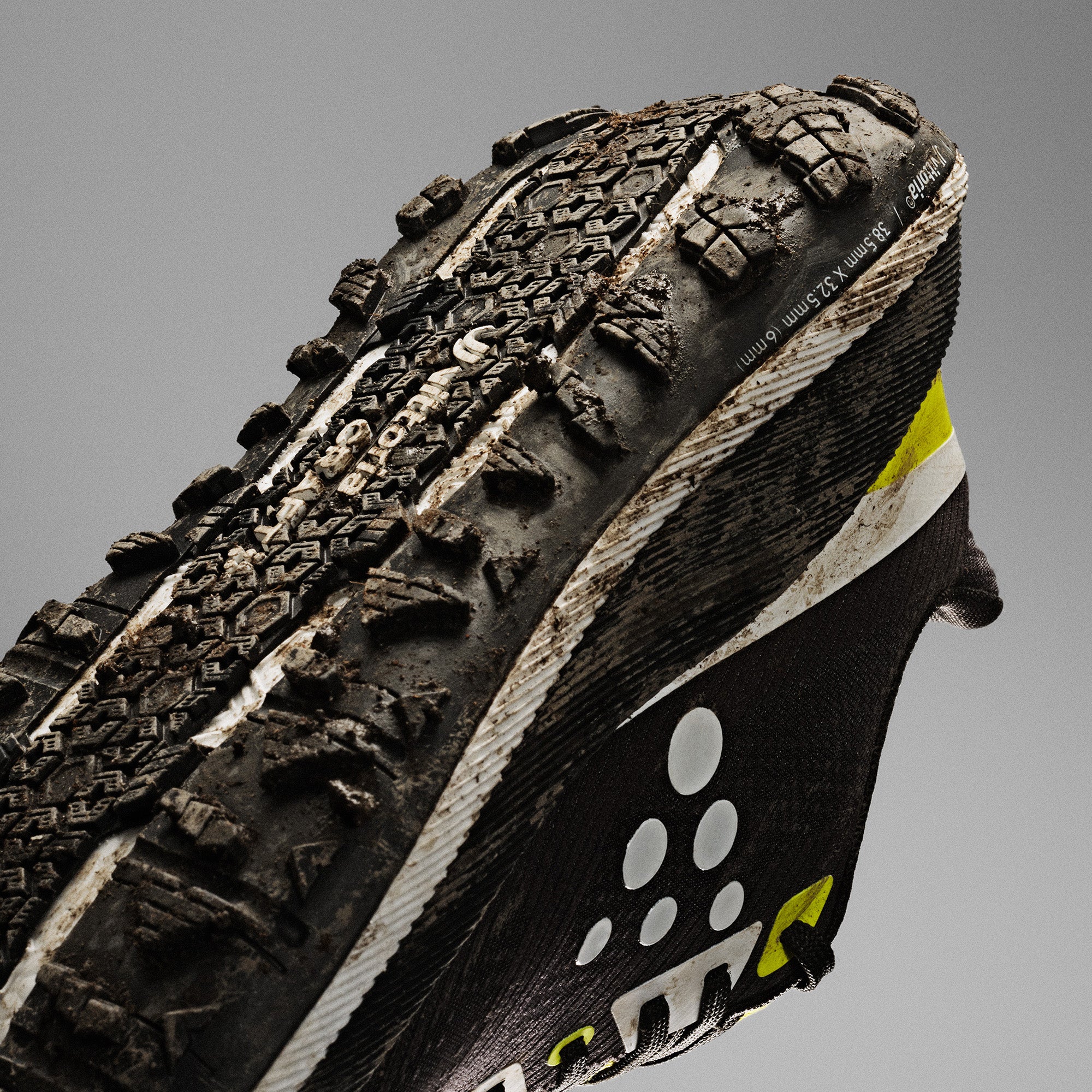 Close-up of a rugged shoe sole with tread pattern on a gray background